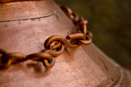 a close up of a copper punja. The Punja is praying around the temple