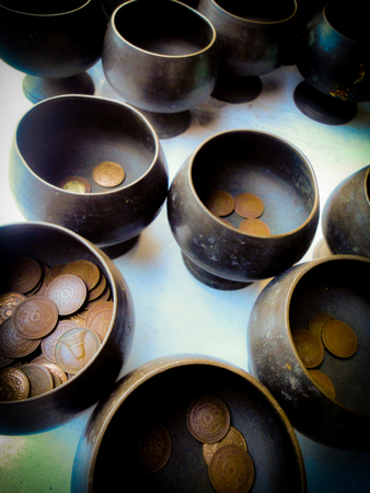 The sacrificial bowls in the temple are filled with Satang coins by the visitors, this gift is supposed to bring good luck. Thailandの写真素材