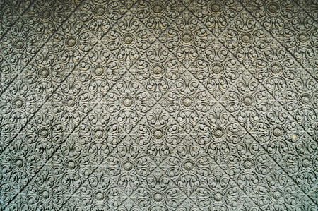 A cement wall of a Buddhist temple. These flower fields were handcrafted into the wall, they are not...