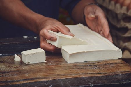 This fresh tofu is made on large layers of wood and cut into portions of large pieces. Sumatra, Indonesia.の写真素材