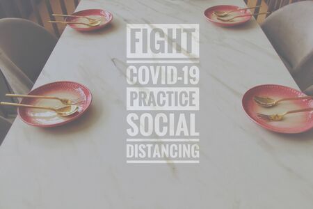 Conceptual still life photo of empty plate with cutlery with the message promoting social distancing, self isolation and home quarantine to prevent the spread of covid-19 pandemicの写真素材