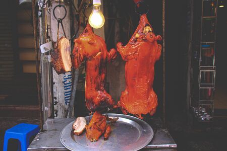 Cantonese style suckling pig roast, a popular street food in Old Quarter or French Quarter of Hanoi,...