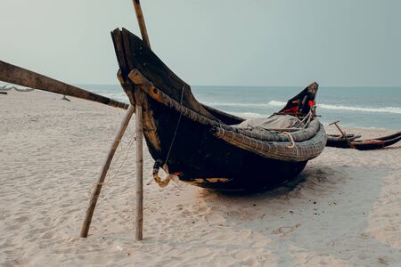 Traditional Vietnamese wooden boats on the shore that shows the effect of lock down, quarantine and...