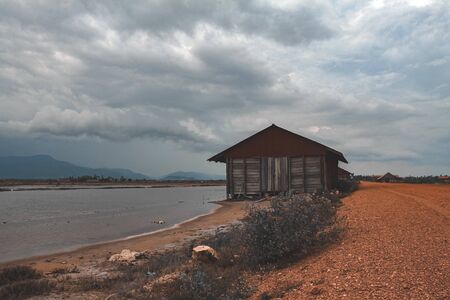 Cinematic photo of an abandoned salt storage house in the famous salt fields of Kampot, shows the effect of covid-19 lock downs on the local industry, economy and livelihood of the Cambodian peopleの写真素材
