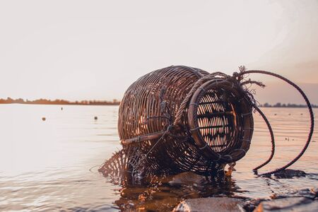 Woven rattan creel or fishing basket that is a traditional fish container in rural fishing village in Cambodia that shows authentic life and local cultureの写真素材