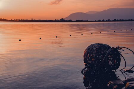 Woven rattan creel or fishing basket that is a traditional fish container in rural fishing village in Cambodia that shows authentic life and local cultureの写真素材