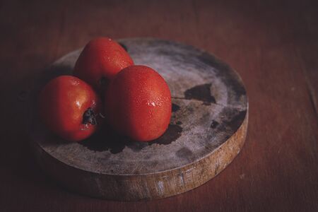 Red tomatoes shot in low light to show concept of gastronomy, clean living and healthy dietの写真素材