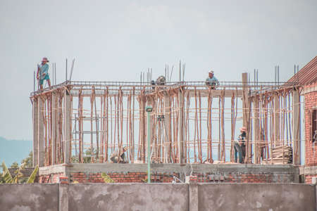 Editorial use only. Construction workers on top of building scaffolding in Kampot, Cambodiaのeditorial素材