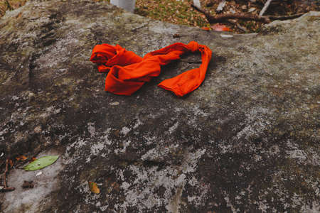 Saffron robe used by Theravada Buddhist Monks left on the temple groundsの写真素材
