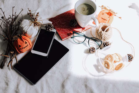 Still life with a cup of tea, smartphone and book reader showing the concept of a relaxing Autumn afternoonの写真素材
