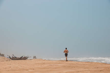 Woman running on the beach in Goa, India. Copy space for textの写真素材