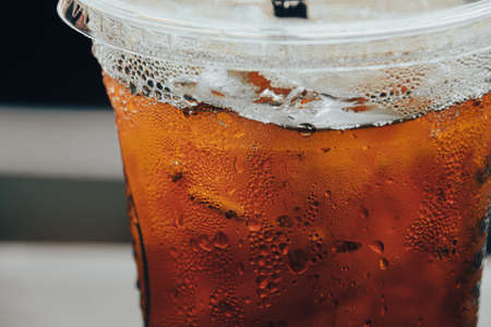 Close up of iced tea with ice cubes inside a plastic cup