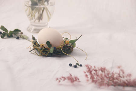 Delicate nest of flowers cradling an egg, Easter theme background