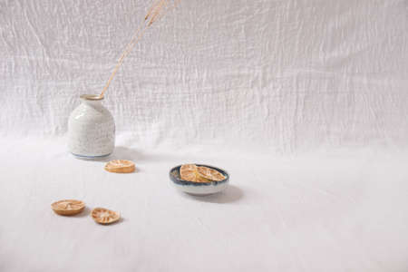 Dried lemon slices on a white delicate background showing the concept and feeling of Spring and Summerの写真素材
