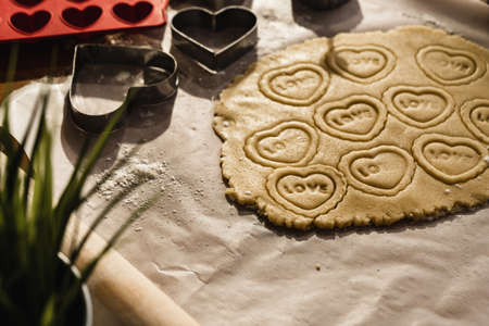 Preparing heart print cookies in raw dough rolled with oklova.の写真素材