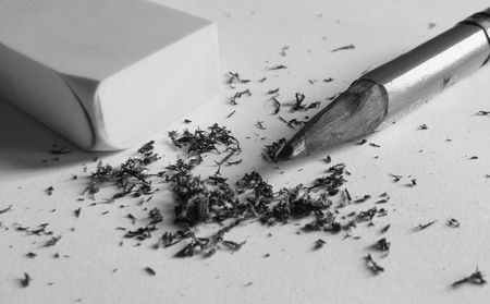 Eraser against a pencil with eraser crumbs in betweenの写真素材