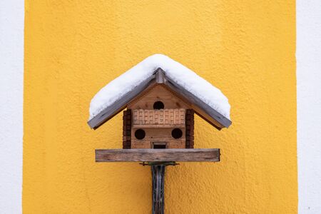 Homemade wooden bird's feeder in winter, under snow.の写真素材