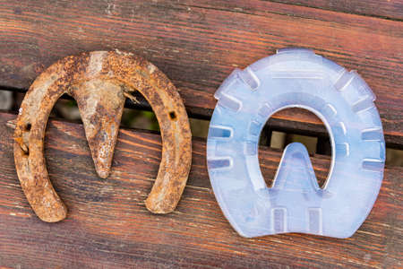 Old rusty iron horseshoe vs modern plastic horseshoe made of composite material which provide better...