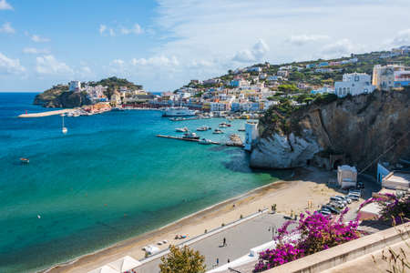 The port of the Ponza island in summer. Colored houses, boats, ferry in the harbor of island of Ponza. People on a free beach along Via Dante Alighieri.のeditorial素材