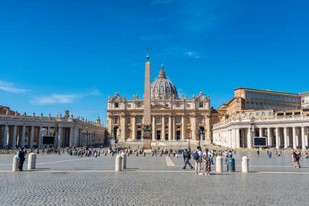 The tourists on the Vatican St. Peter's square. The panoramic view of the dome of Saint Peter's Basilica and its statues of saints. Vatican City, Italy - 09.22.2021のeditorial素材