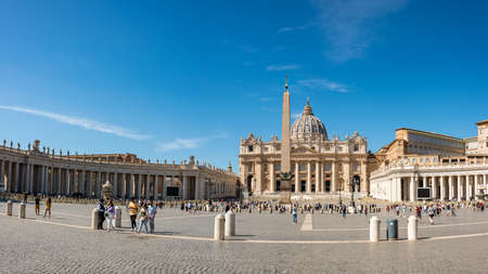 The tourists on the Vatican St. Peter's square. The panoramic view of the dome of Saint Peter's Basilica and its statues of saints. Vatican City, Italy - 09.22.2021のeditorial素材