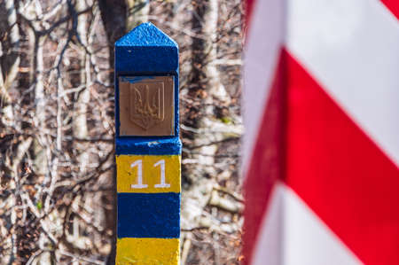 Border markes on a Polish-Ukraine boundary. The Polish eastern border, is also the border of the European Union and NATO. In the background, the blue sky and trees, bushes and grass of Bieszczady Mountains National Park, Polandの写真素材