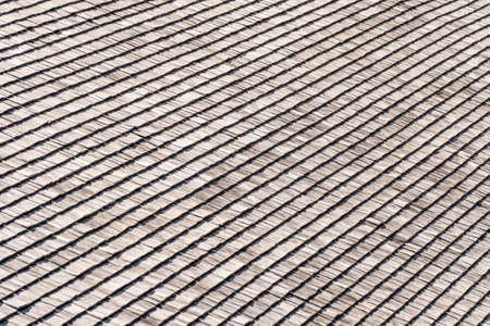Weathered and faded from the sun, rain and snow wooden shingles that are the facade of an alpine...