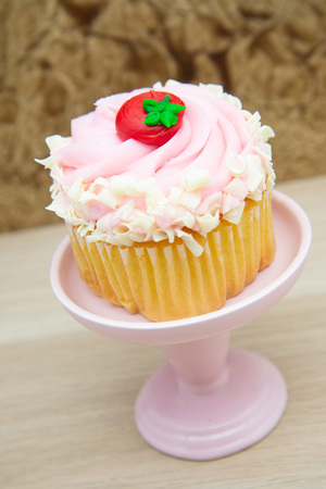 strawberry cupcake with pink frosting on a dessert display stand pillar pedestal.の写真素材