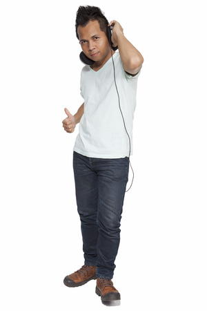 Full length portrait of a handsome young man asian listening to music indoorの写真素材