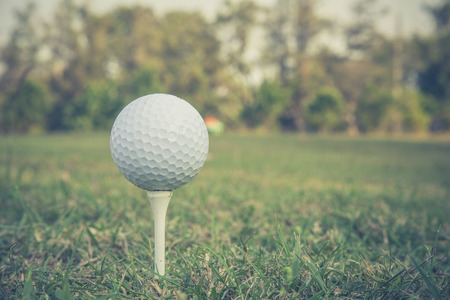 Close up of golf ball on a tee  at sunrise on frosty morning Close up of golf ball on a tee  at sunrise on frosty morning and vintage style の写真素材