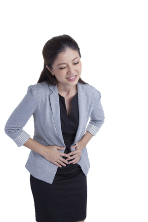 Businesswoman with stomach issues in white backgroundの写真素材