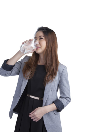 Young businesswoman drinking water on water glass isolated on white background の写真素材