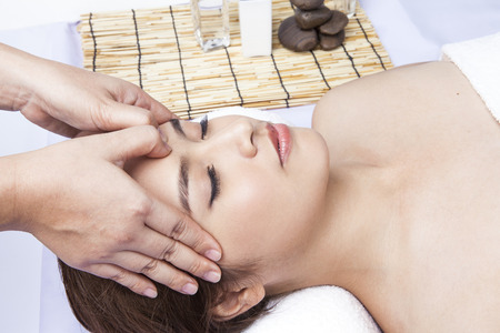 Young attractive girl having head massage at spa resortの写真素材