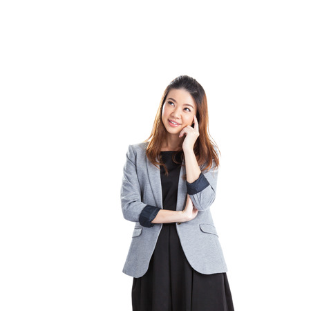 Thinking business woman standing pensive contemplating looking up for inspiration. Beautiful  Asian businesswoman isolated on white background in full body.の写真素材