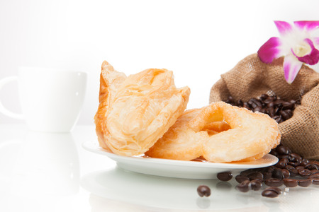 Continental breakfast with assortment of pastries, coffees and flower Orchid in studio shot on coffee beans and white background.の写真素材