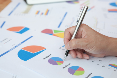 Close-up of graph product and writing business plan for meeting preparation in office.の写真素材