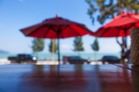 Wood table top on blurred blue sea and white sand beach background - can be used for display or montage your productsの写真素材