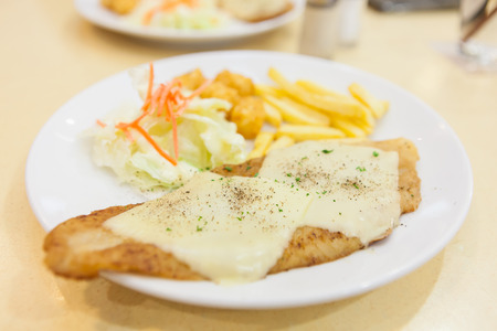 Grilled dolly fish steak meal served with salad and French friesの写真素材
