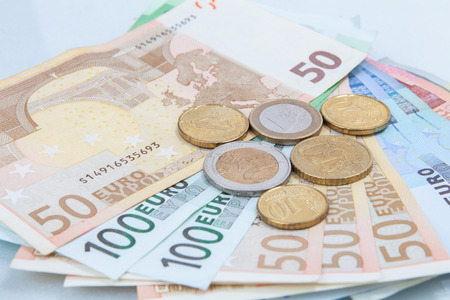 Money euro coins and banknotes in studio on white background.の写真素材