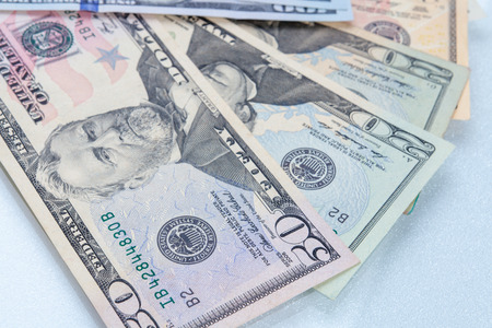 Multiple scattered American 100 dollar banknotes in full frame coverage with corner vignetting viewed from above in a conceptual financial backgroundの写真素材