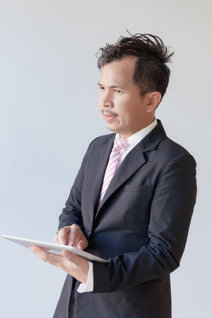 Portrait young businessmen using touchpad / Focus touchscreen to tablet for presentの写真素材