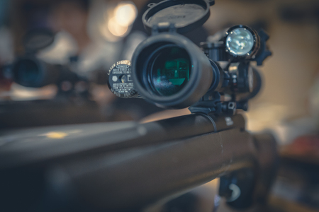 Closeup of a sniper rifle telescope glass lens on shop backgroundの写真素材