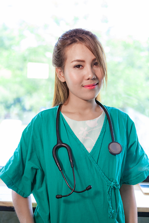 Doctor with a stethoscope in hospital on green background.の写真素材
