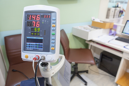 A Hospital Vital Sign Monitor on Trolley with Blood Pressure Cuff and Thermometer equipment on hospital background.の写真素材