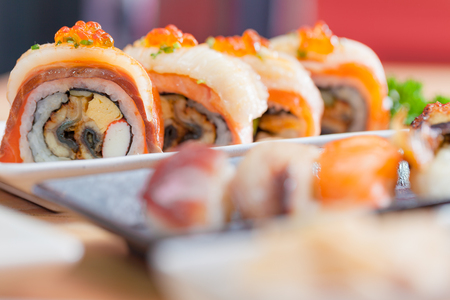 Maki. Closeup maki set at white plate on wooden table. japanese food concept.の写真素材