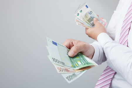 Business Man Displaying a Spread of Cash over isolated a white backgroundの写真素材