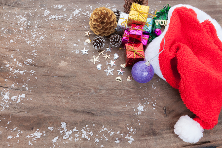 Christmas background with christmas ball, gift, red hat and snow on a wooden background/ Christmas backgroundの写真素材