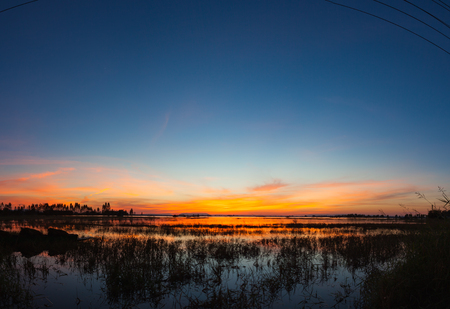 Panoramic sunset reflection in a lake at Ubonrat dam, Khon Khan city, Thailand.の写真素材