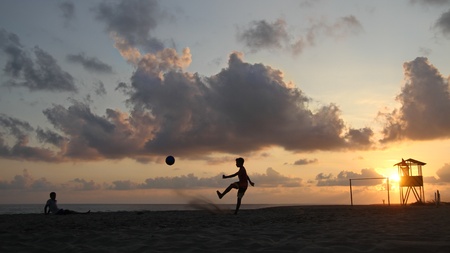 Football on the beach during sunsetの写真素材