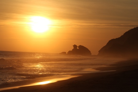 Sunset in ocean close to promontoryの写真素材